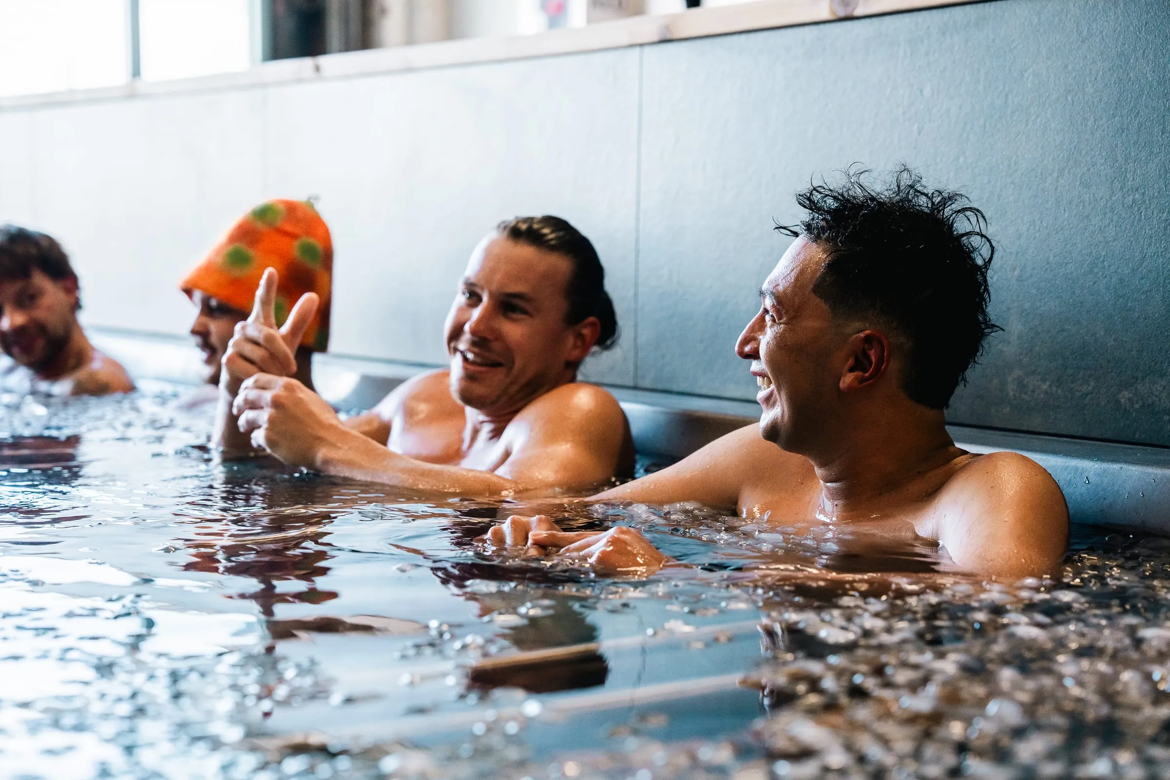 Friends laughing in the cold plunge in Denver